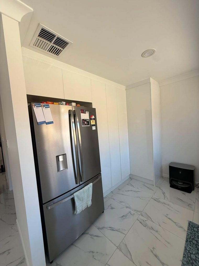 Custom floor-to-ceiling cabinetry in a renovated kitchen and pantry area