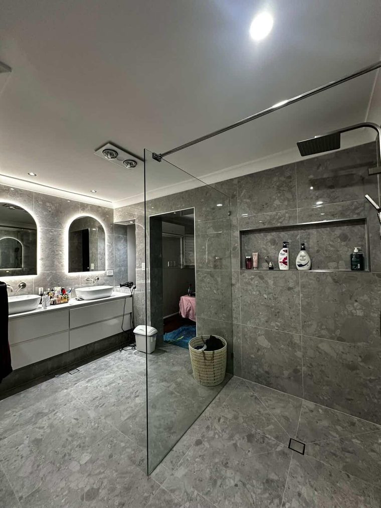 Large ensuite with a double vanity, backlit arched mirrors and a walk-in shower