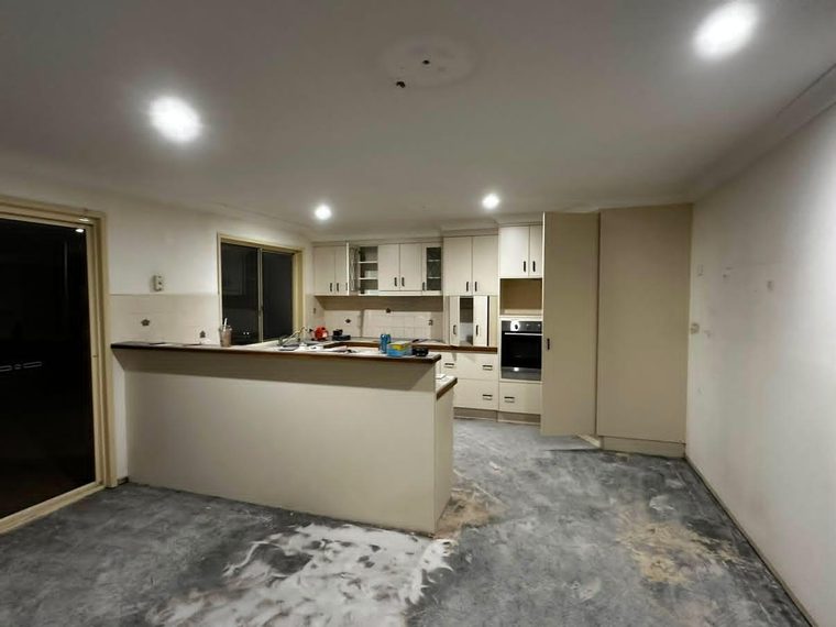 Kitchen mid-renovation with the new island bench set out on the bare slab